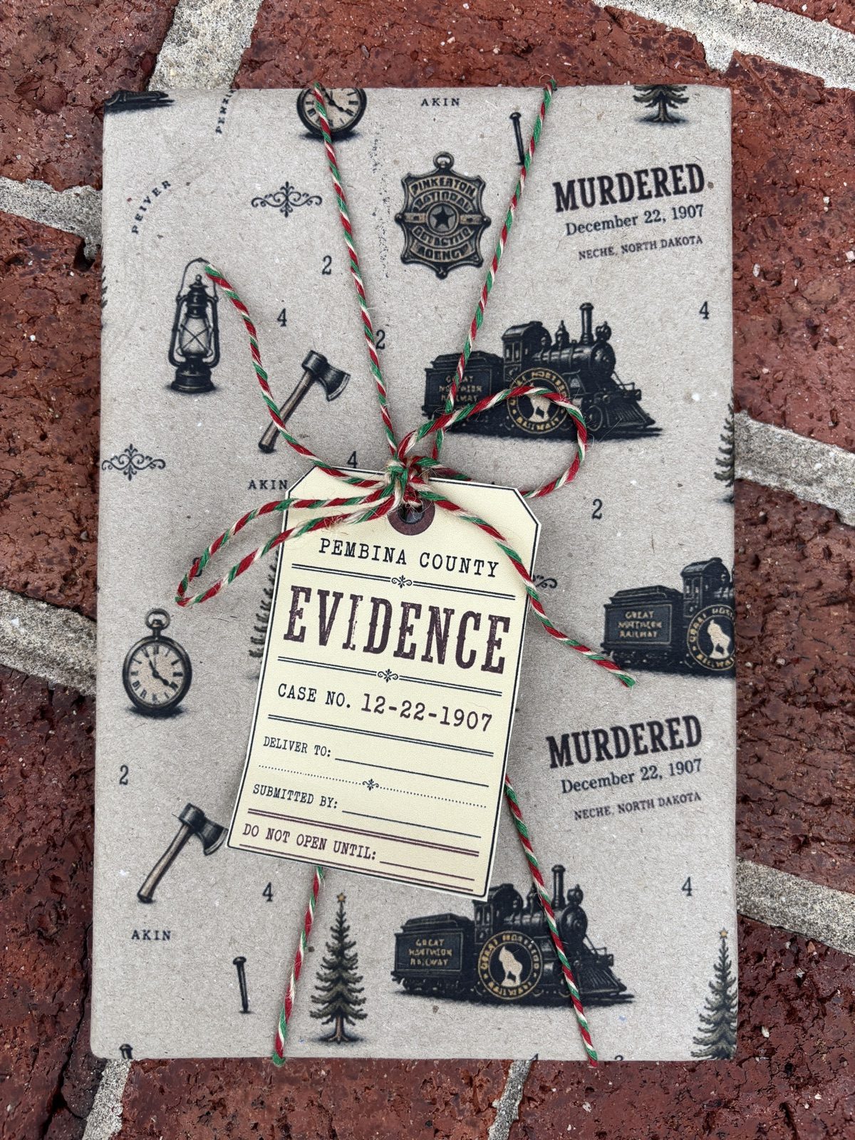 A signed copy of A Murder for Christmas in custom gift wrap with a Pembina County evidence tag